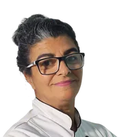 Chef Rita Lonato de dólmã branco, sorrindo, de braços cruzados